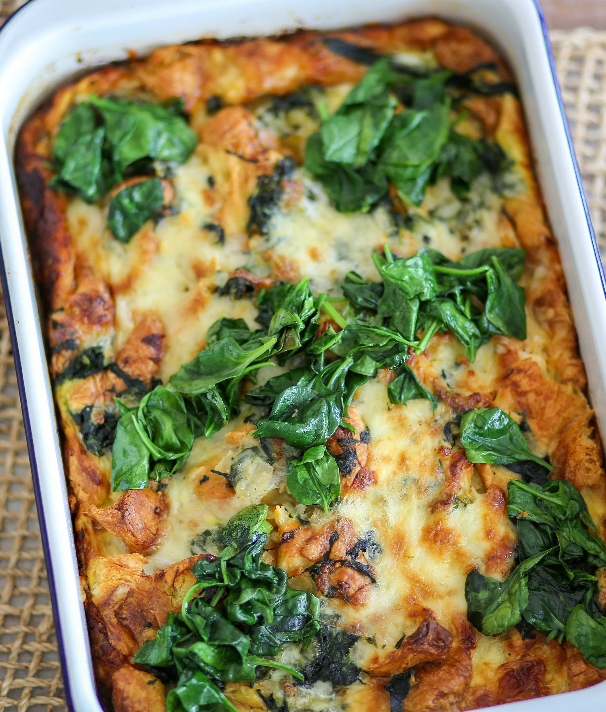 A casserole dish with spinach and cheese on top.
