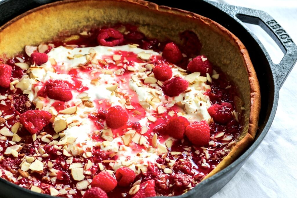 A pan of food with raspberries and almonds.