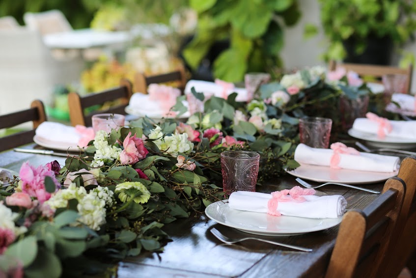 A table set with plates and flowers on it.