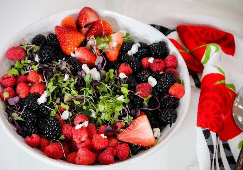 A bowl of fruit is shown with strawberries, blackberries and raspberries.