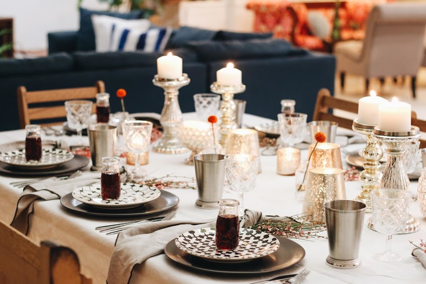 A table set with candles and plates on it.