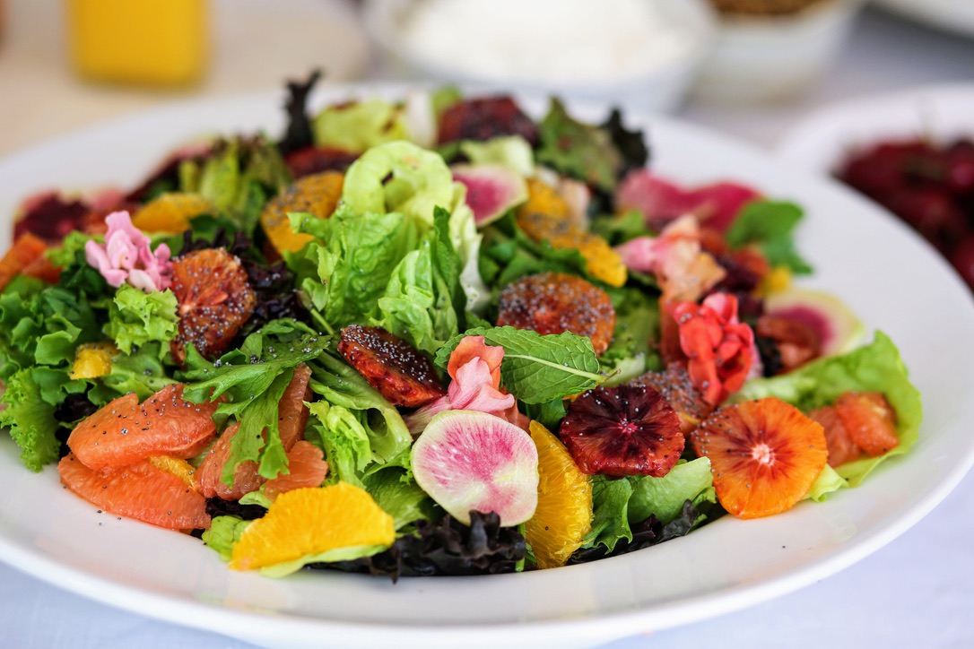 A plate of salad with dressing on top.