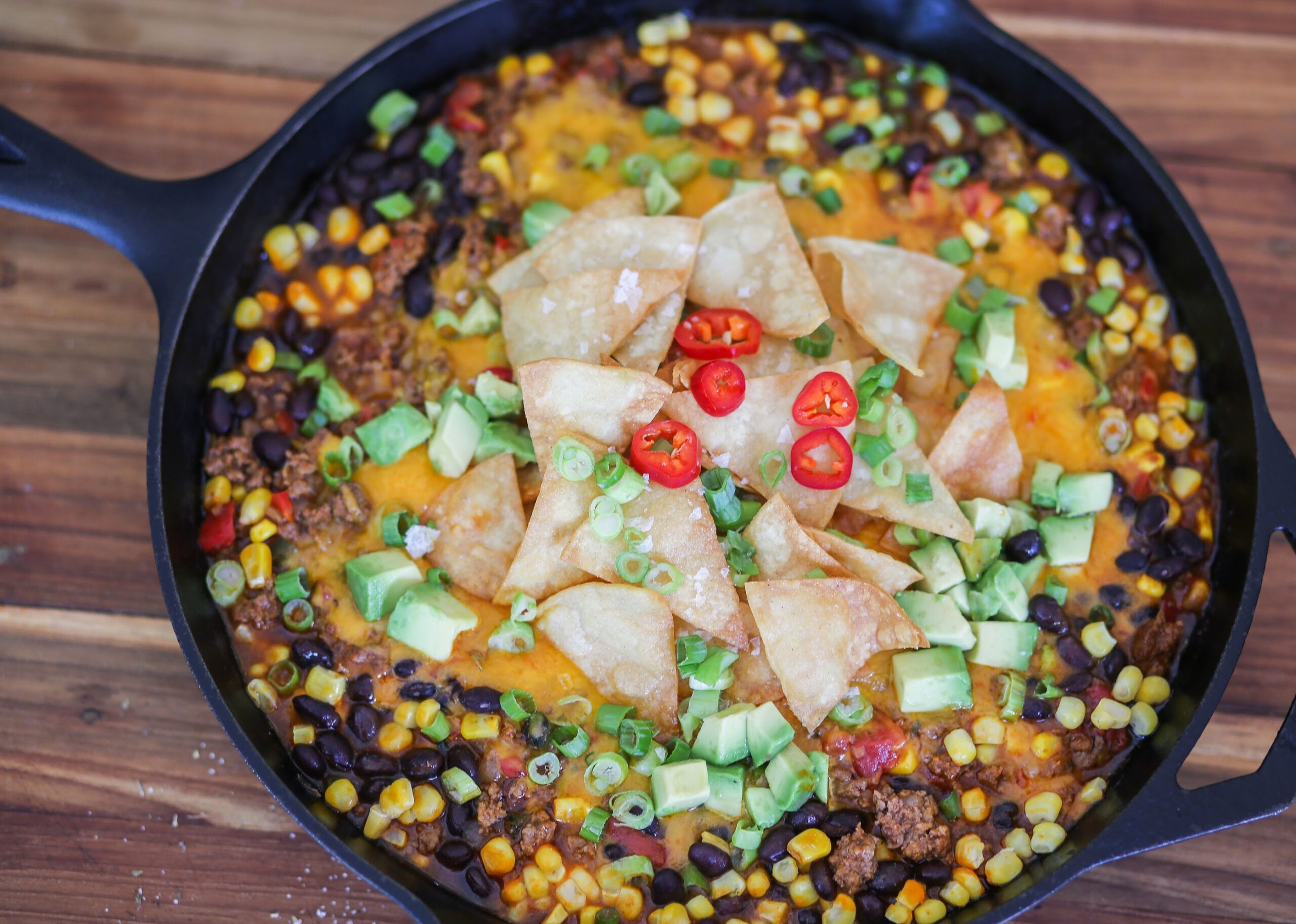 A pan of food with meat, beans and corn.