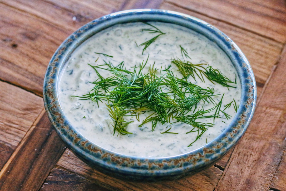 A bowl of soup with herbs on top.