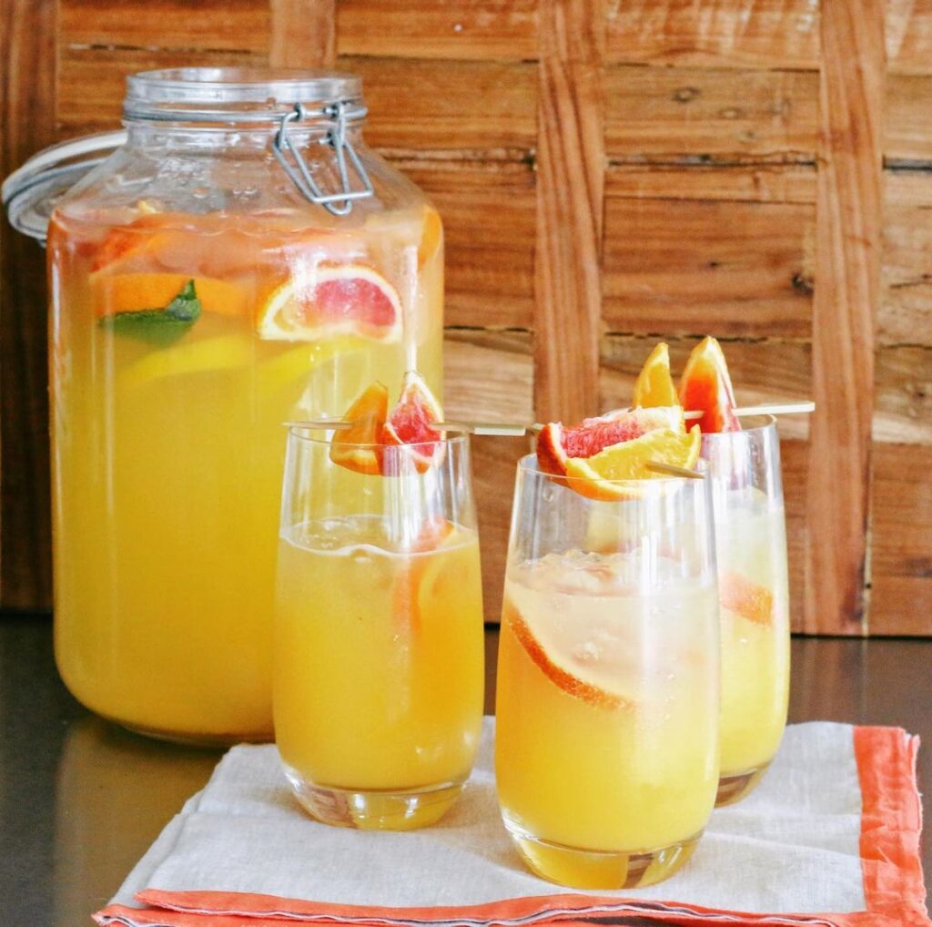 A pitcher and two glasses of lemonade on a table.