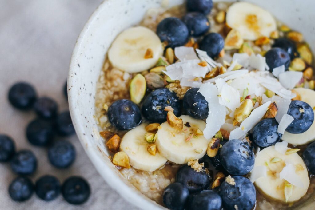 A bowl of oatmeal with bananas and blueberries.