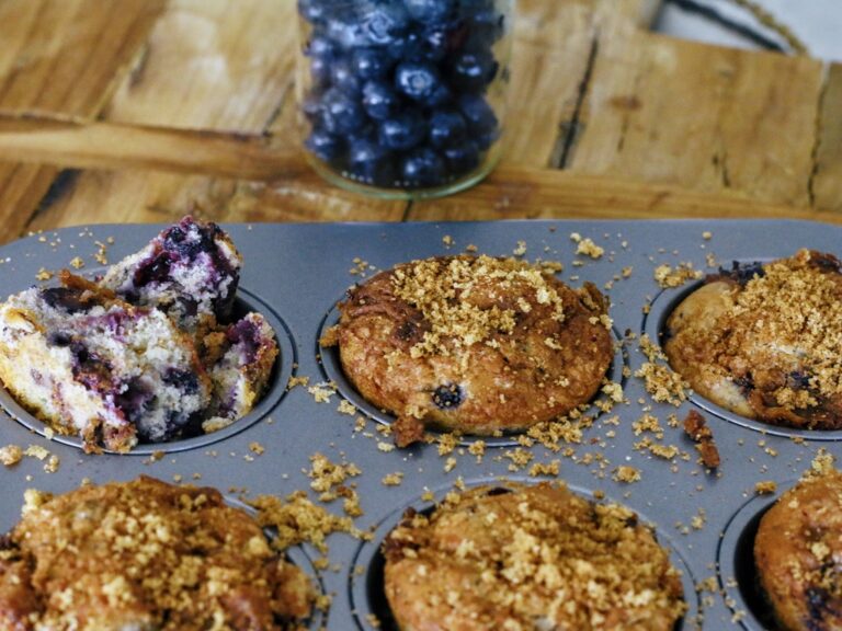 A muffin tin with some blueberry muffins in it