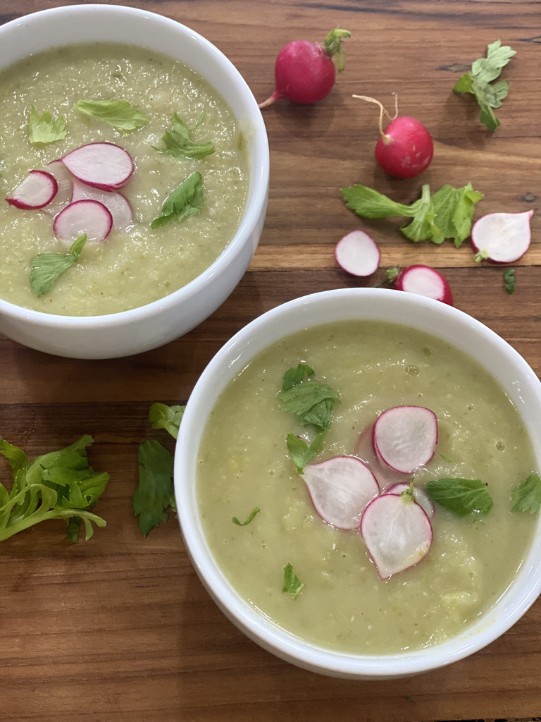 Two bowls of soup with radishes on top.
