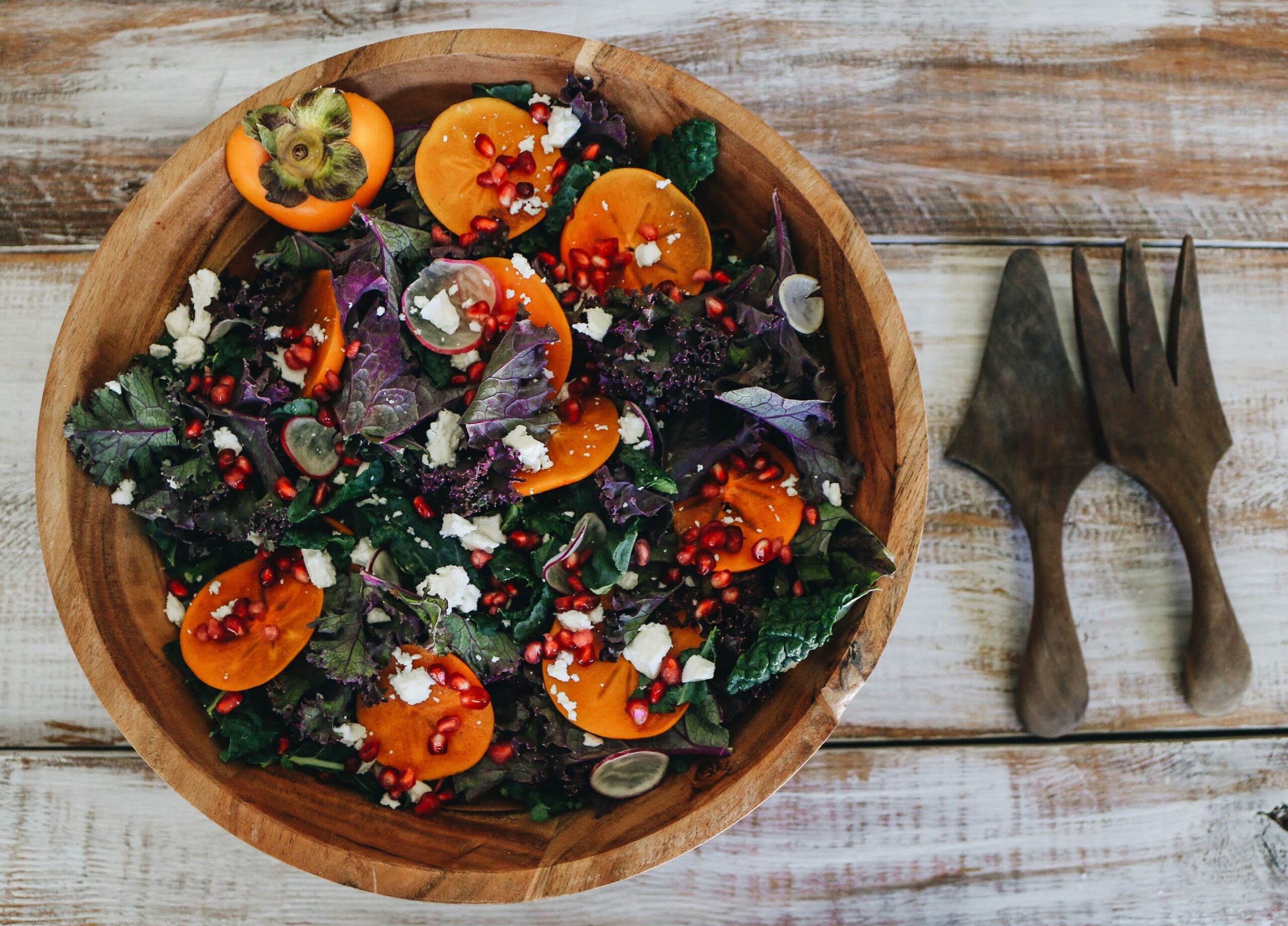 A bowl of salad with tomatoes, carrots and other vegetables.