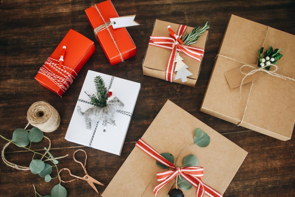 A table with several different types of gifts wrapped in brown paper.