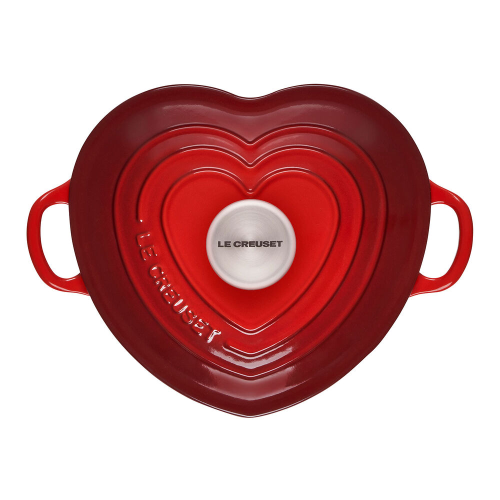 A red heart shaped pot with two handles.