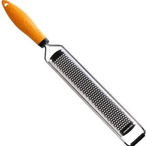 A grater with orange handle is sitting on the floor.