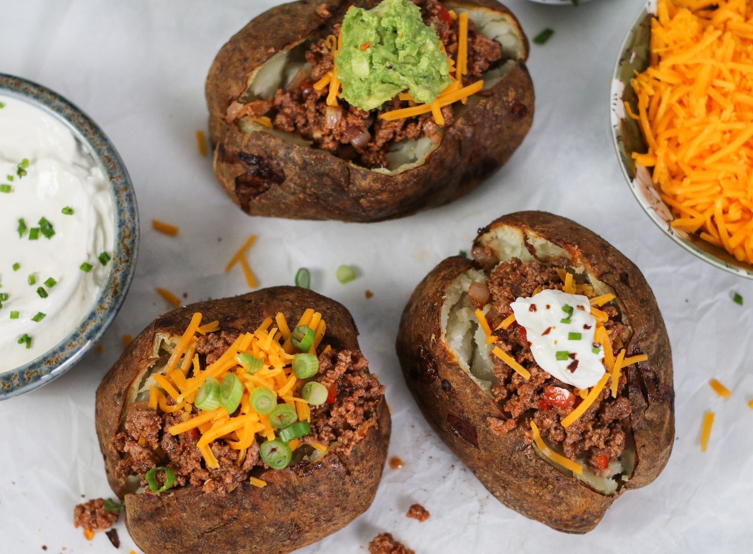 A close up of baked potatoes with toppings