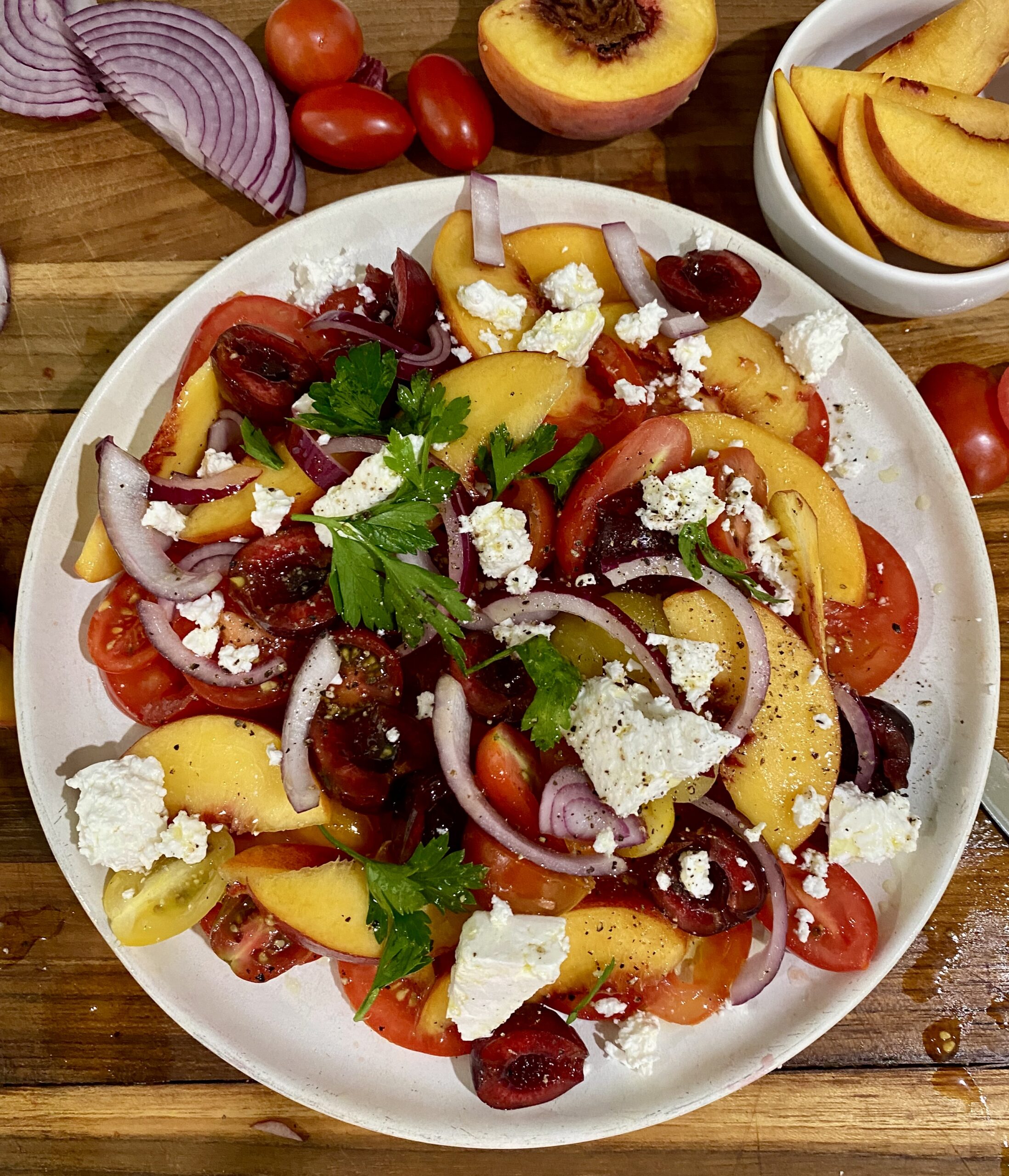 A white plate topped with salad and fruit.