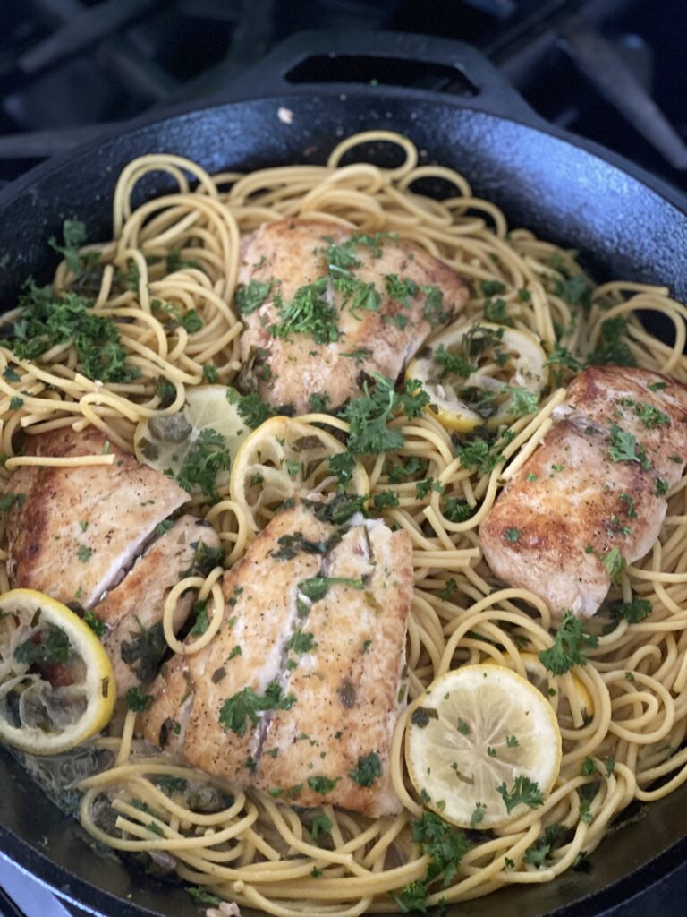 A pan of pasta with chicken and lemon.