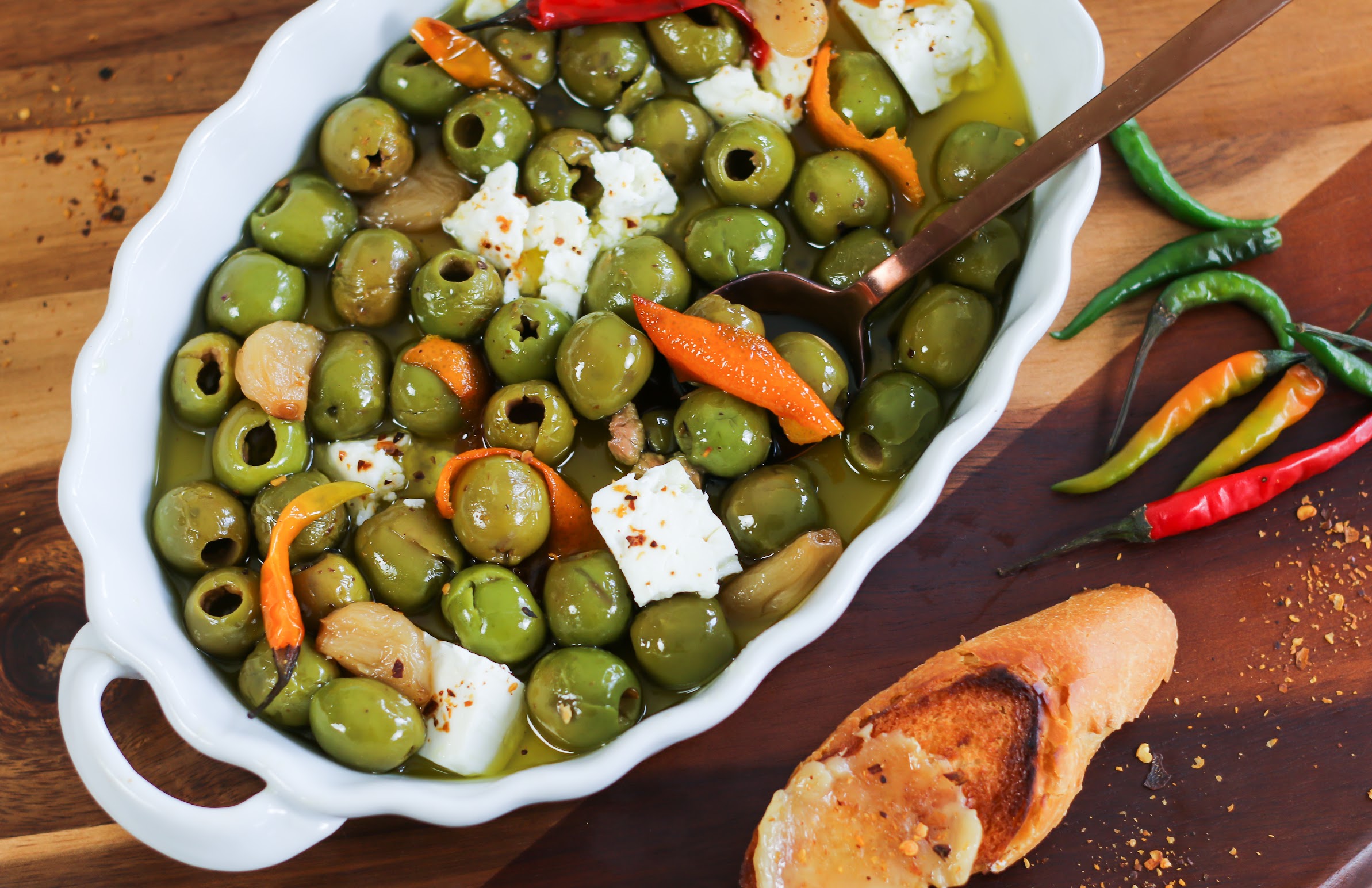 A bowl of olives and other vegetables on a table.