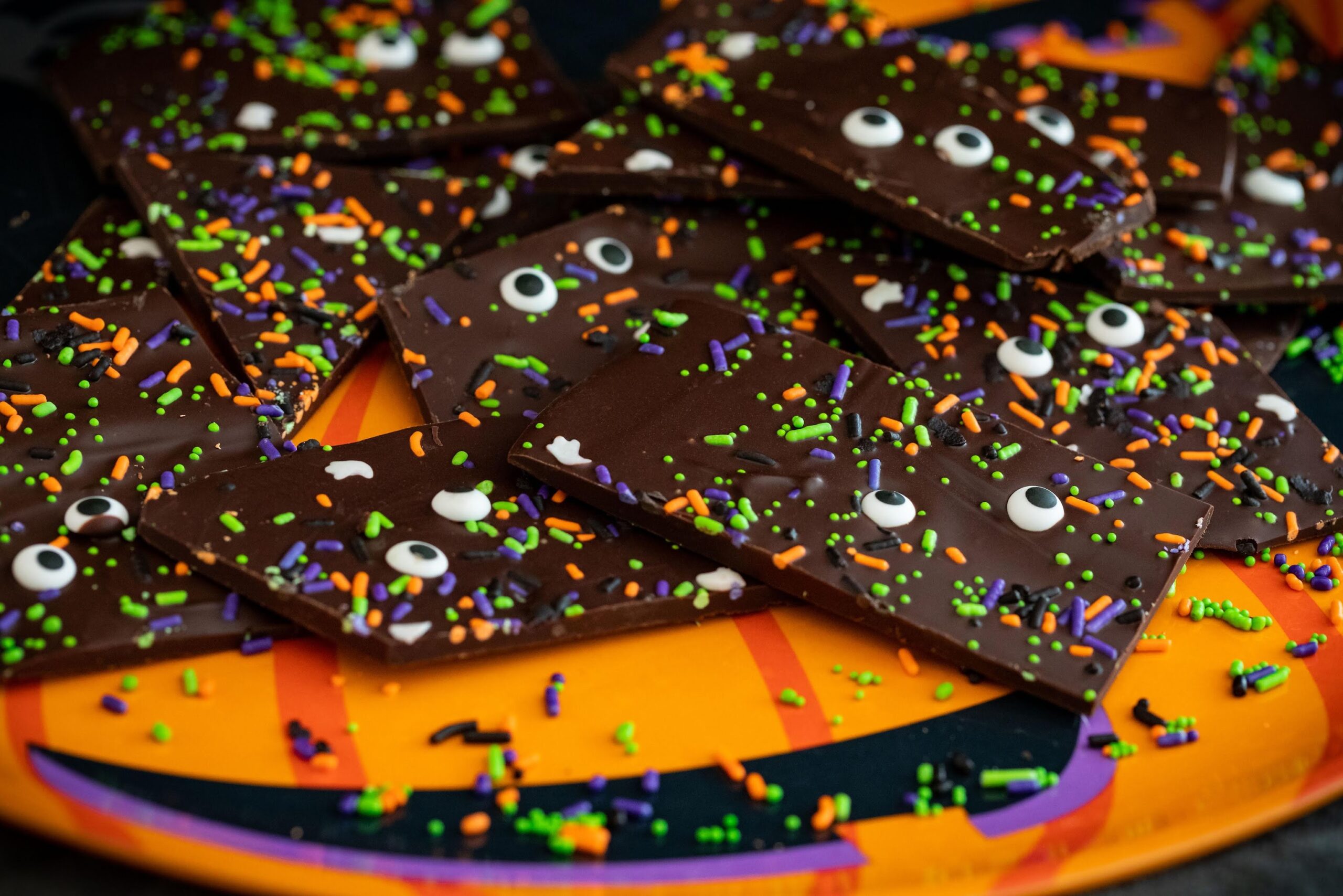 A plate of chocolate covered candy with eyes on it.