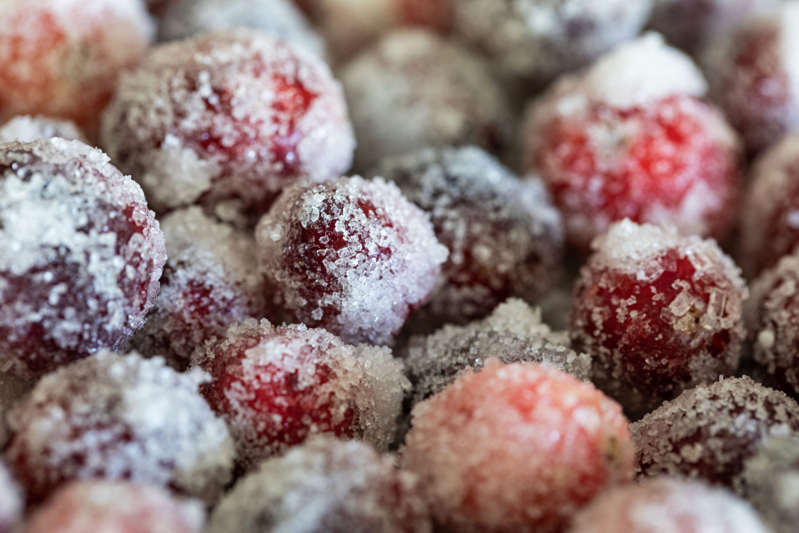 A close up of frozen raspberries in the snow
