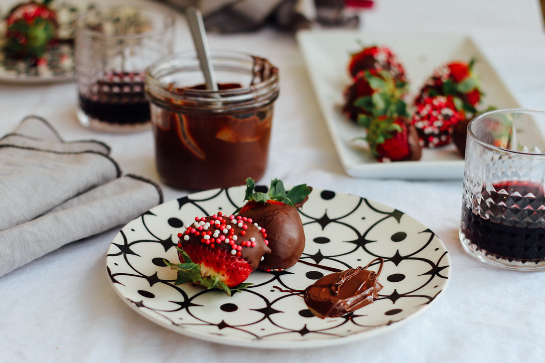 A plate with chocolate covered strawberries on it