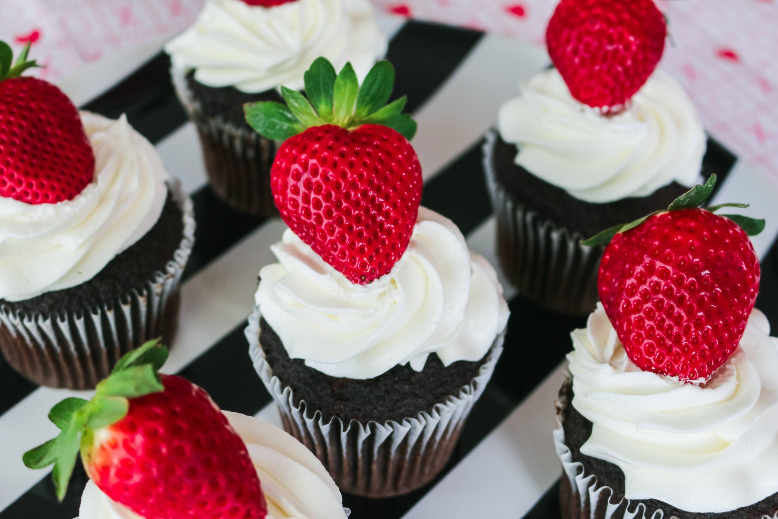 A close up of cupcakes with strawberries on top