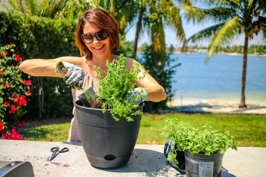 A woman is holding onto some plants in a pot