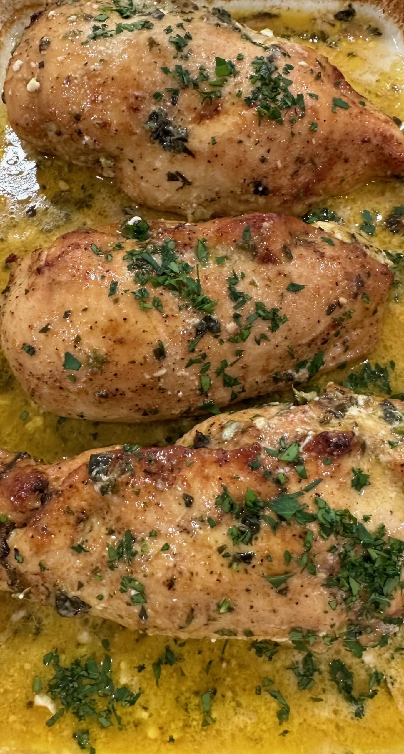 A close up of some chicken with herbs on top