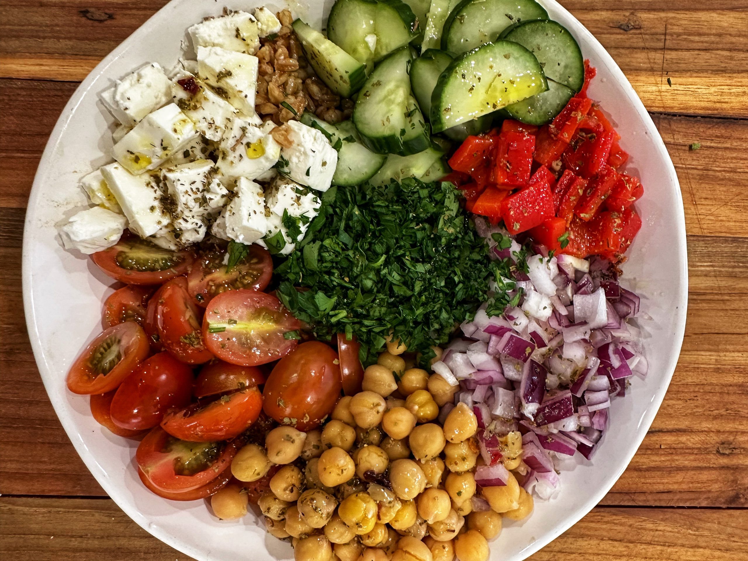A bowl of food with different vegetables and garnish.