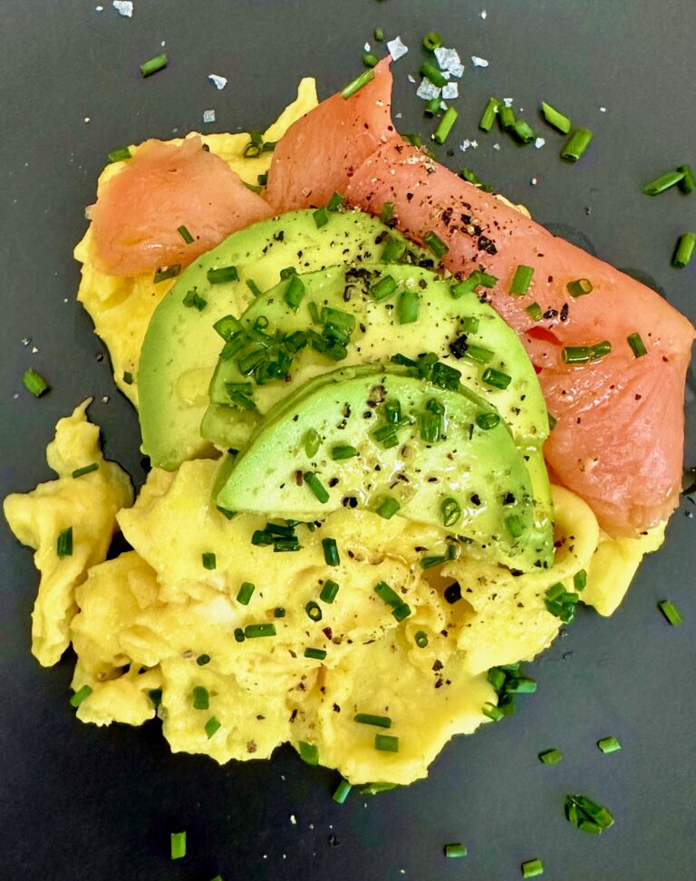 A plate of food with salmon and avocado.