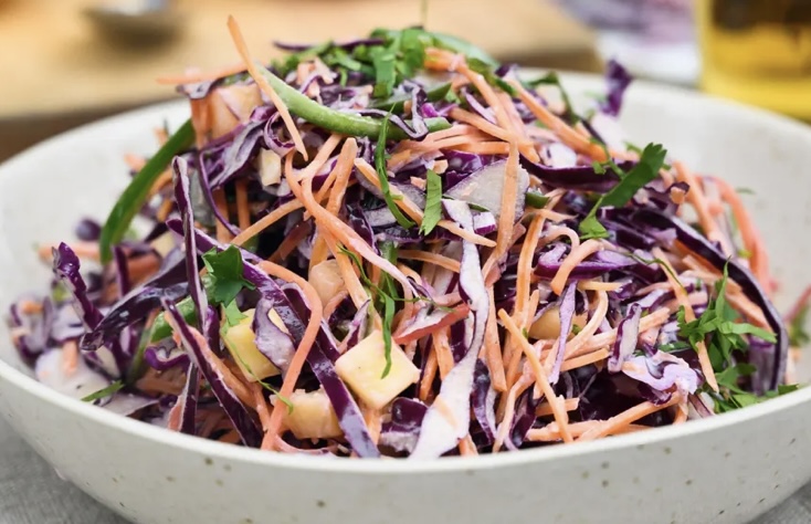 A bowl of salad with carrots and cabbage.