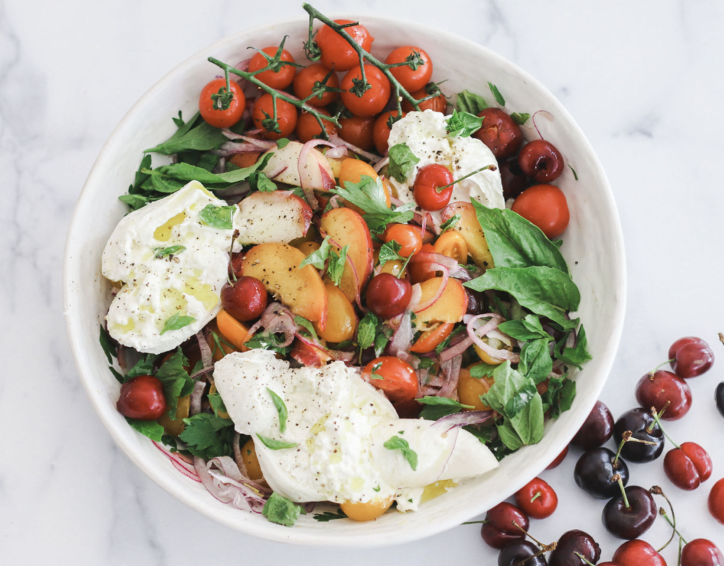 A bowl of salad with tomatoes, mozzarella and basil.