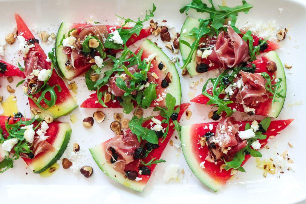 A plate of watermelon pizza with nuts and cheese.