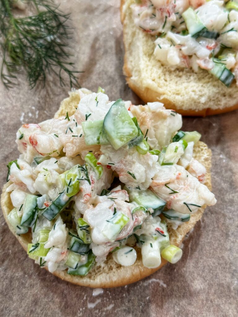 A close up of a sandwich with crab and cucumber