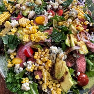 A salad with corn, tomatoes and other vegetables.