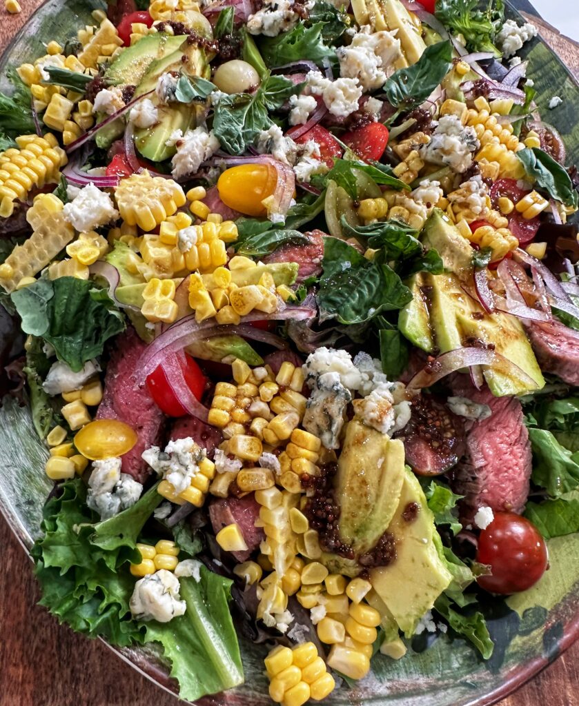 A salad with corn, tomatoes and other vegetables.