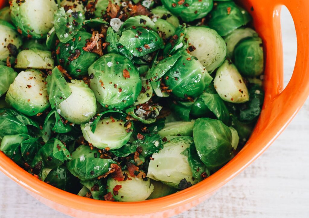 A bowl of brussels sprouts with red pepper.